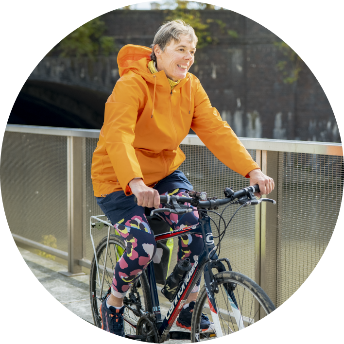 Woman with organge jacket on a bike
