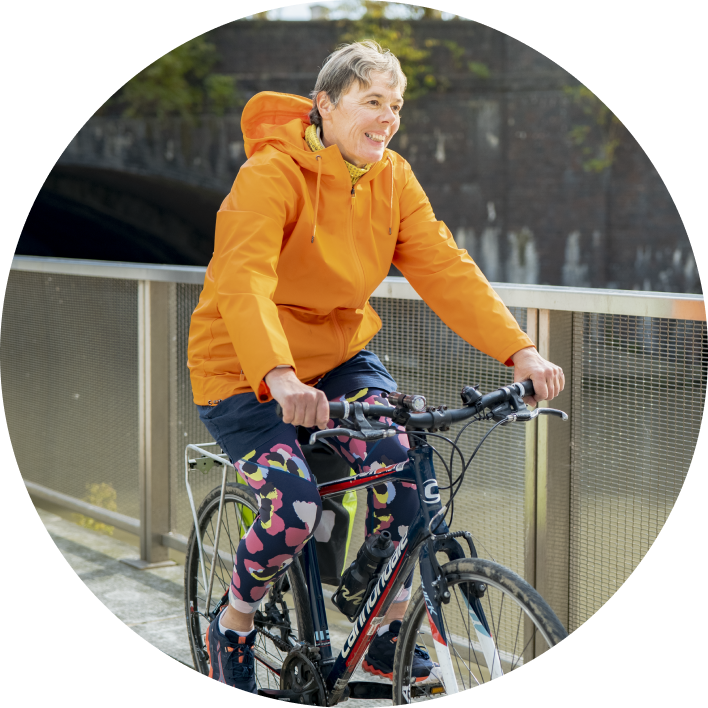 Woman with organge jacket on a bike